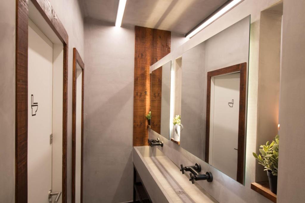 a bathroom with a sink and a mirror at GiG Capsule Hostel in Ericeira