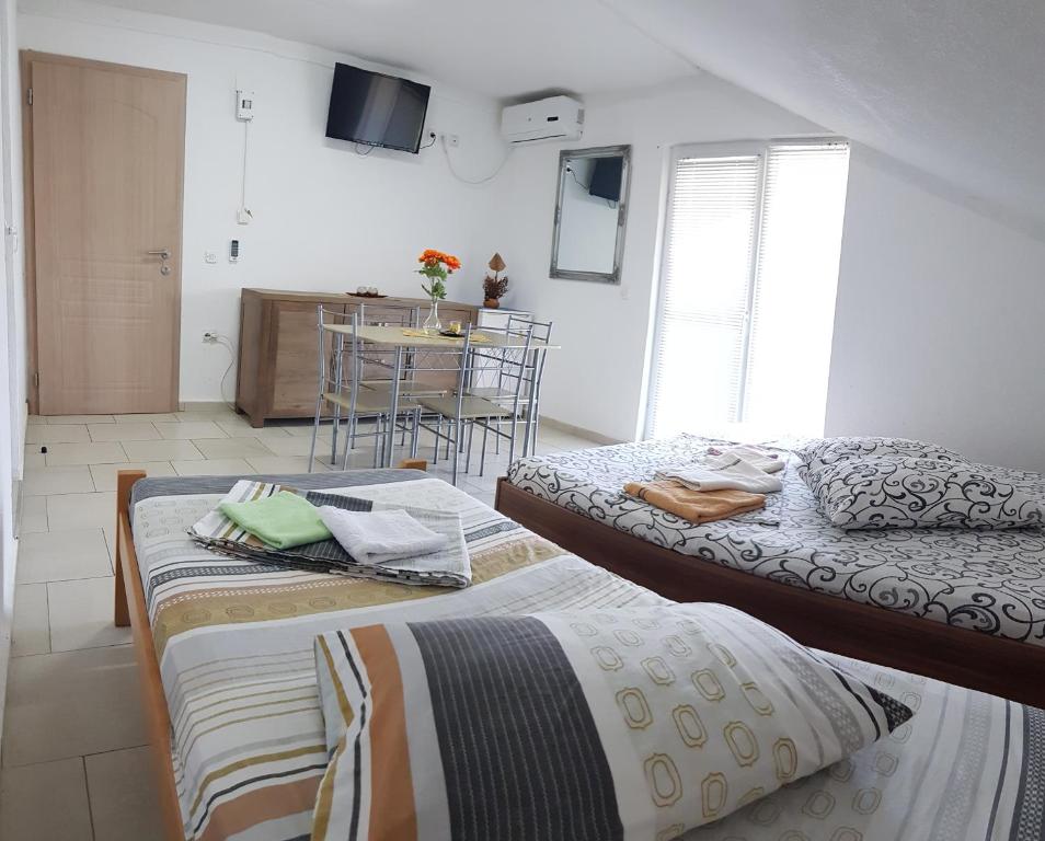 two beds sitting in a room with a kitchen at Guest Home Elena in Star Dojran