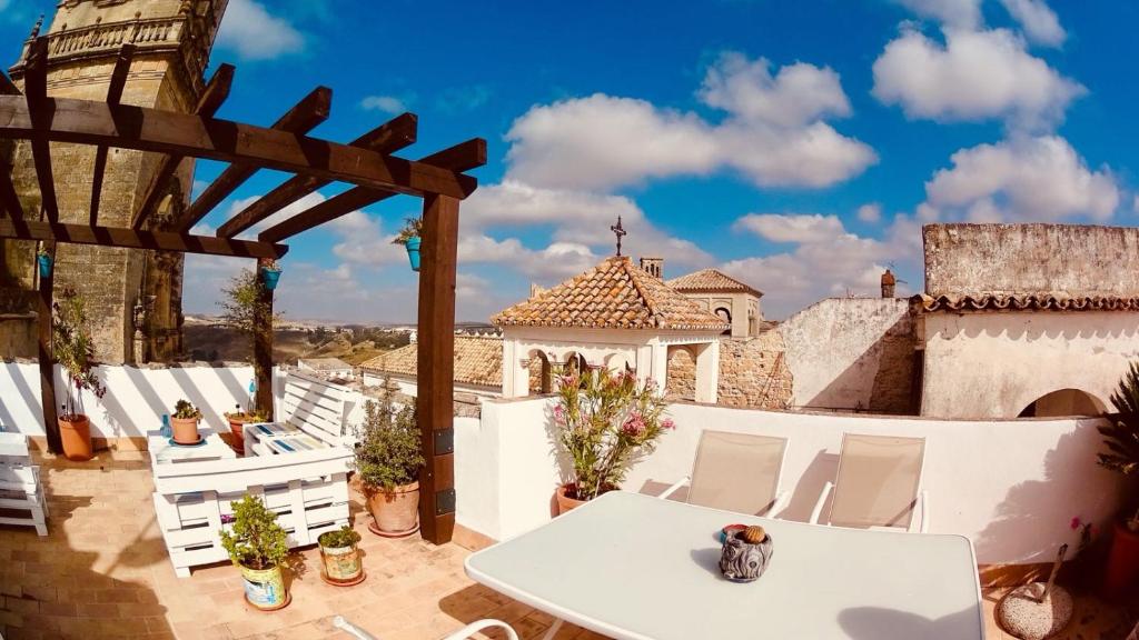 un patio con una mesa blanca y sillas blancas en Casa Mirador San Pedro, en Arcos de la Frontera