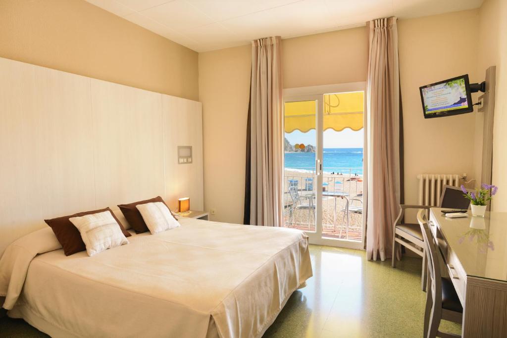 a bedroom with a bed and a view of the ocean at Hotel Capri in Tossa de Mar