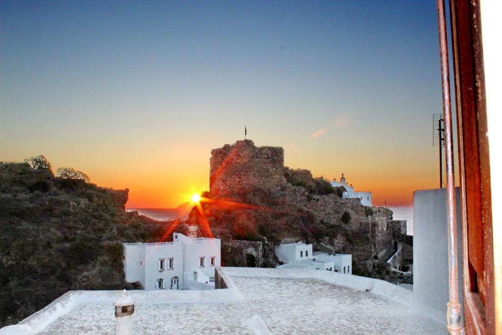 a view of a sunset over a castle on a cliff at La Casa d'Irene in Mandrákion