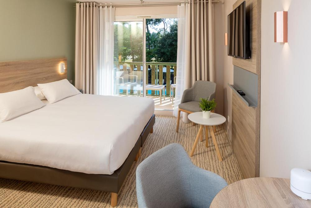 een hotelkamer met een bed en een balkon bij Hôtel Vitalparc in Lacanau-Océan