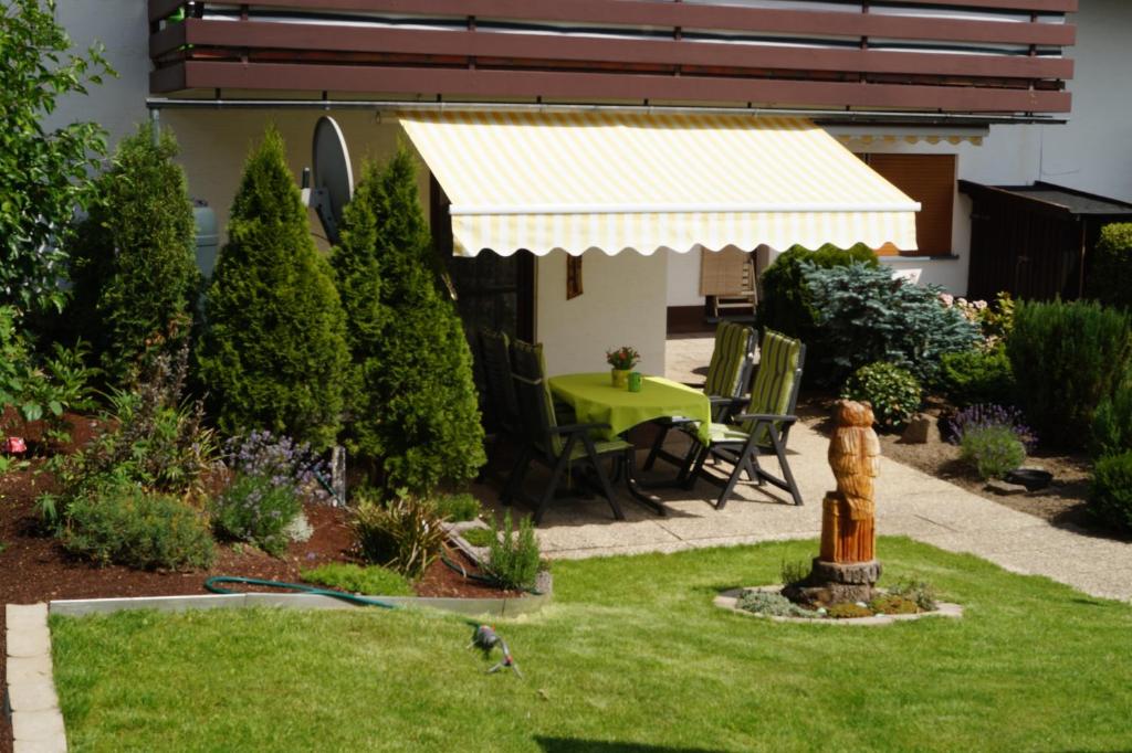 a garden with a yellow awning and a fire hydrant at Feriendomizil-Sauerland FeWo 1 in Medebach