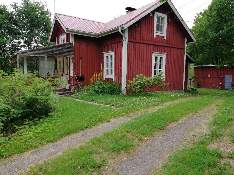 a red house with a dirt road in front of it at Mökki Kujala in Nummi