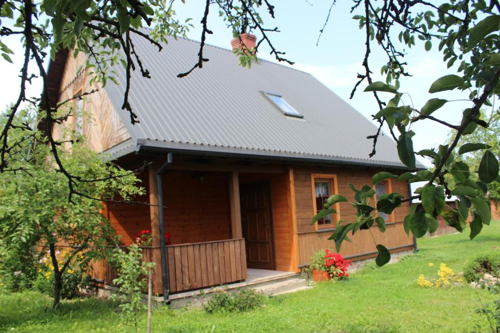 a wooden house with a porch and a door at U Romaniuków in Werstok