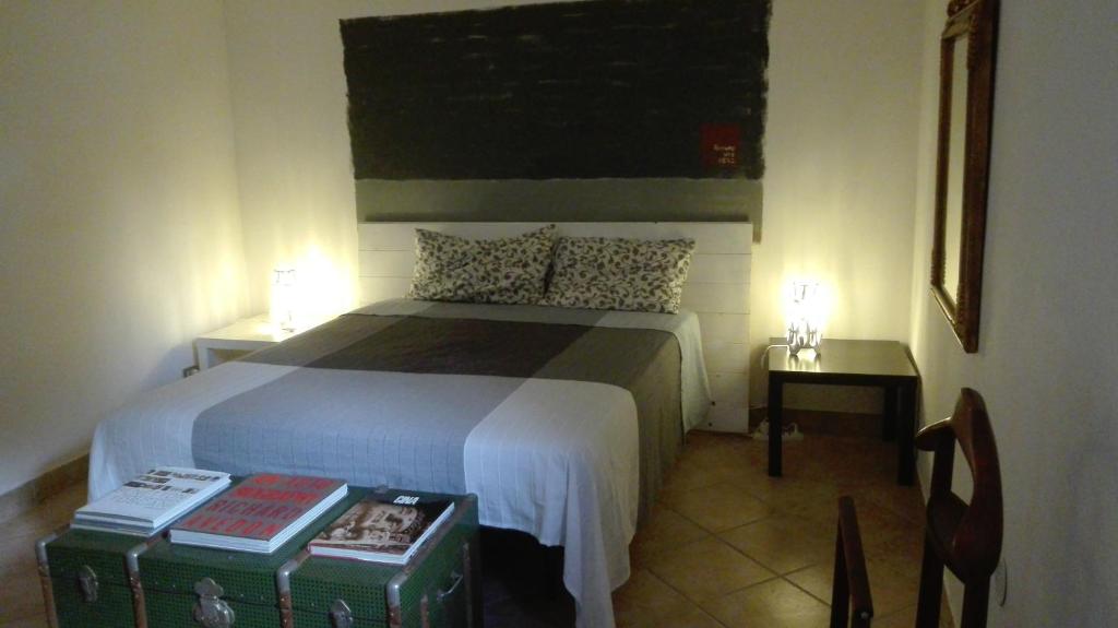 1 dormitorio con 1 cama, 2 mesas y 1 silla en The lake, the sea, the history, en Anguillara Sabazia