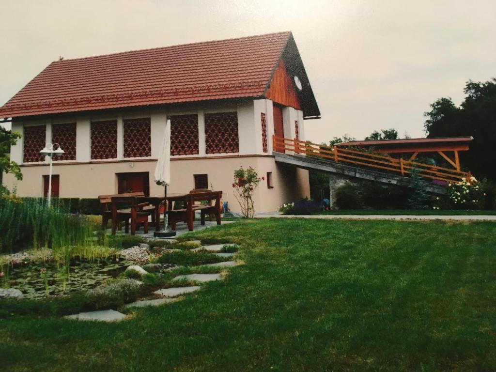 a building with a picnic table in front of a yard at Naturresidenz Kropfitsch in Krumpendorf am Wörthersee