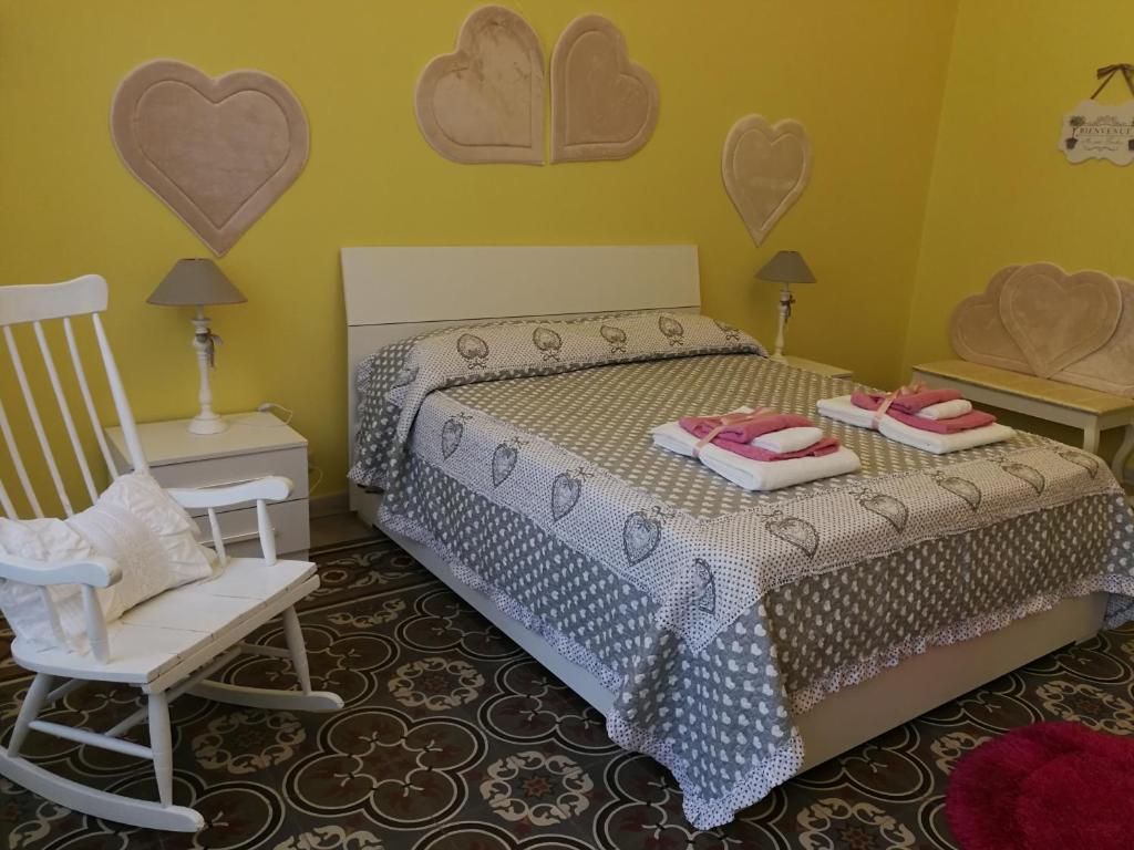 a bedroom with a bed and a chair and hearts on the wall at Appartamento cuore al centro di Taranto in Taranto