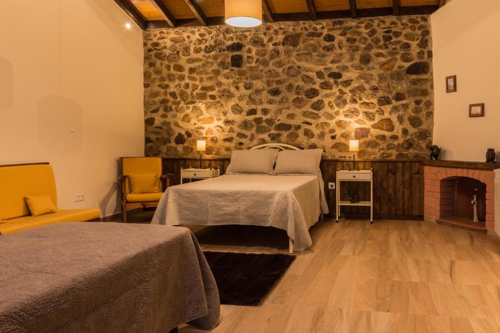 um quarto com uma cama e uma parede de pedra em Portantiqua, guest house em Góis