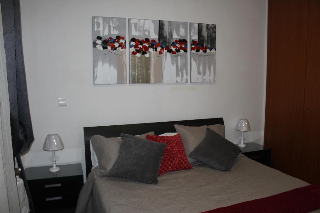 フンシャルにあるUptown Madalenasのベッドルーム1室(壁に3枚の写真が飾られたベッド1台付)