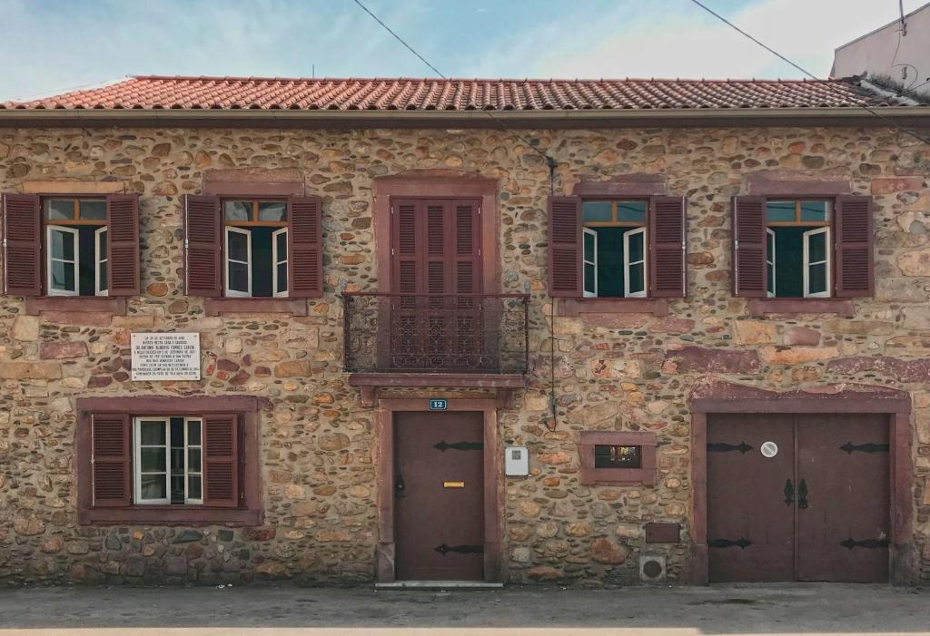 un vecchio edificio in pietra con porte e finestre di Portantiqua, guest house a Góis