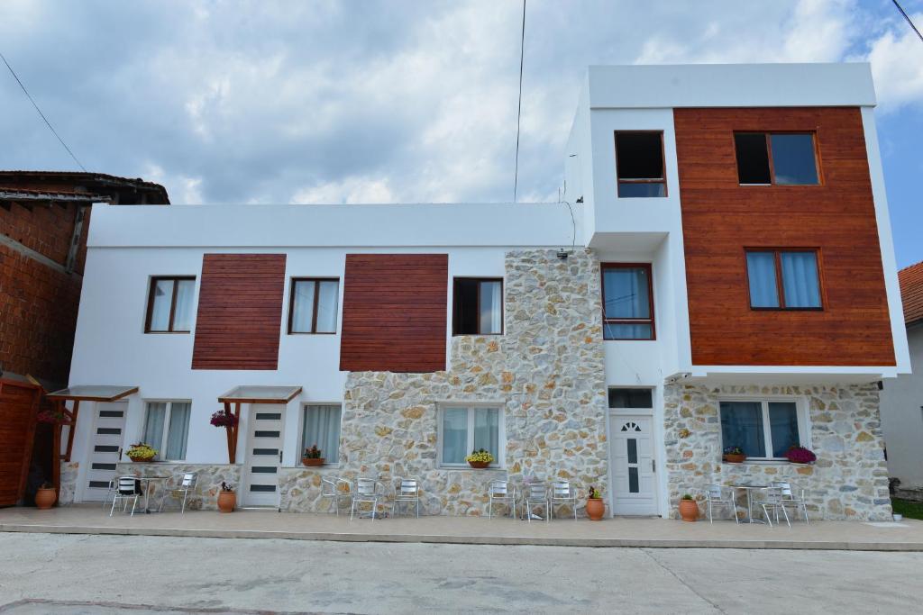 a building with tables and chairs in front of it at Rooms Ela Ela in Prekodolce