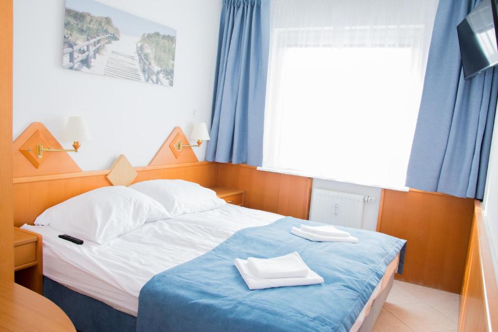 a bedroom with a bed with two towels on it at ApartamentyPrzyMorzu Reymonta z sypialnią in Kołobrzeg