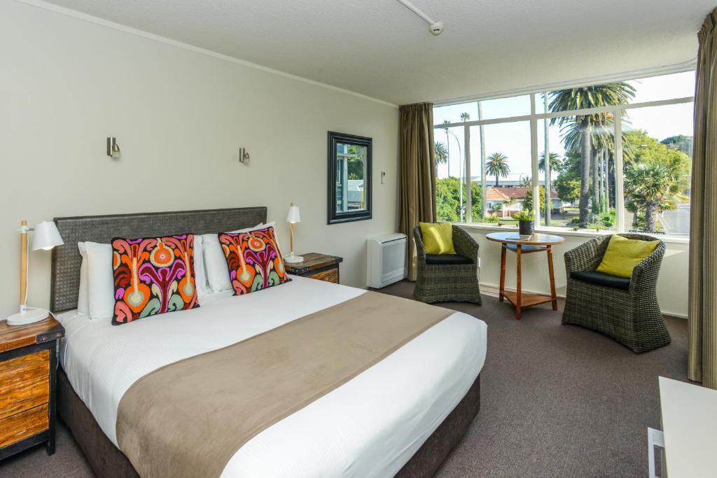 ein Hotelzimmer mit einem Bett und einem großen Fenster in der Unterkunft expressotel in Napier