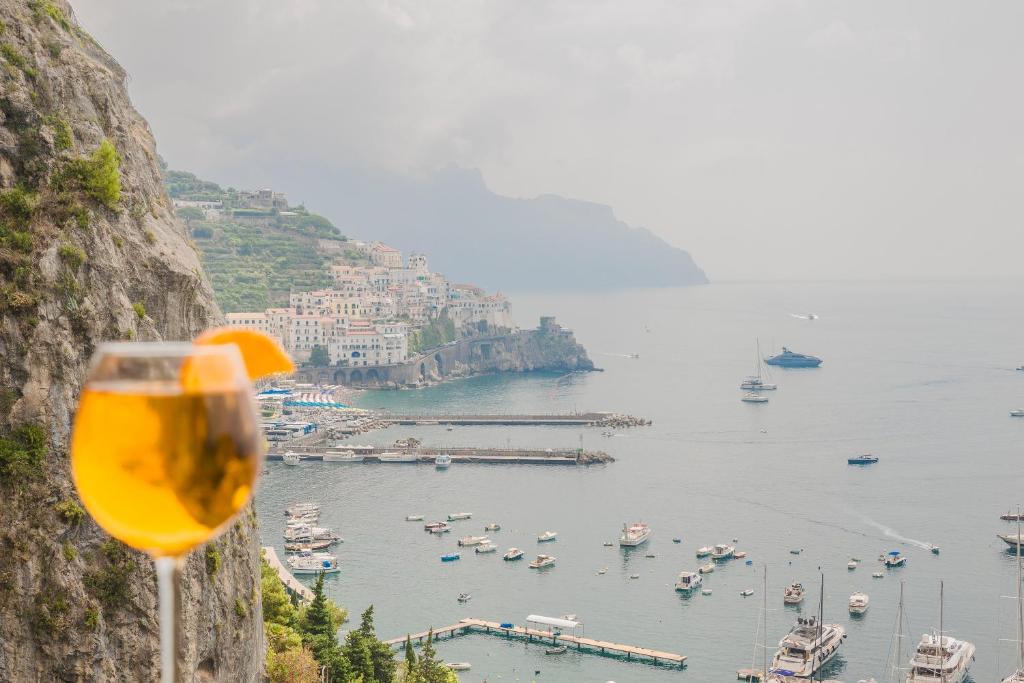 a glass of wine next to a view of a harbor at Belvedere Apartment in Amalfi