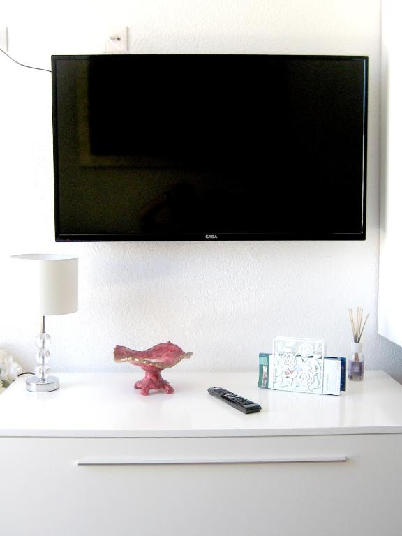 Telewizja i/lub zestaw kina domowego w obiekcie Malibu apartamento con campo de tennis y piscina con solarium