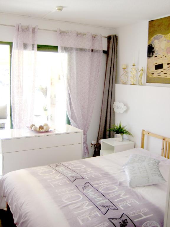 sypialnia z białym łóżkiem i oknem w obiekcie Malibu apartamento con campo de tennis y piscina con solarium w mieście Puerto Rico de Gran Canaria