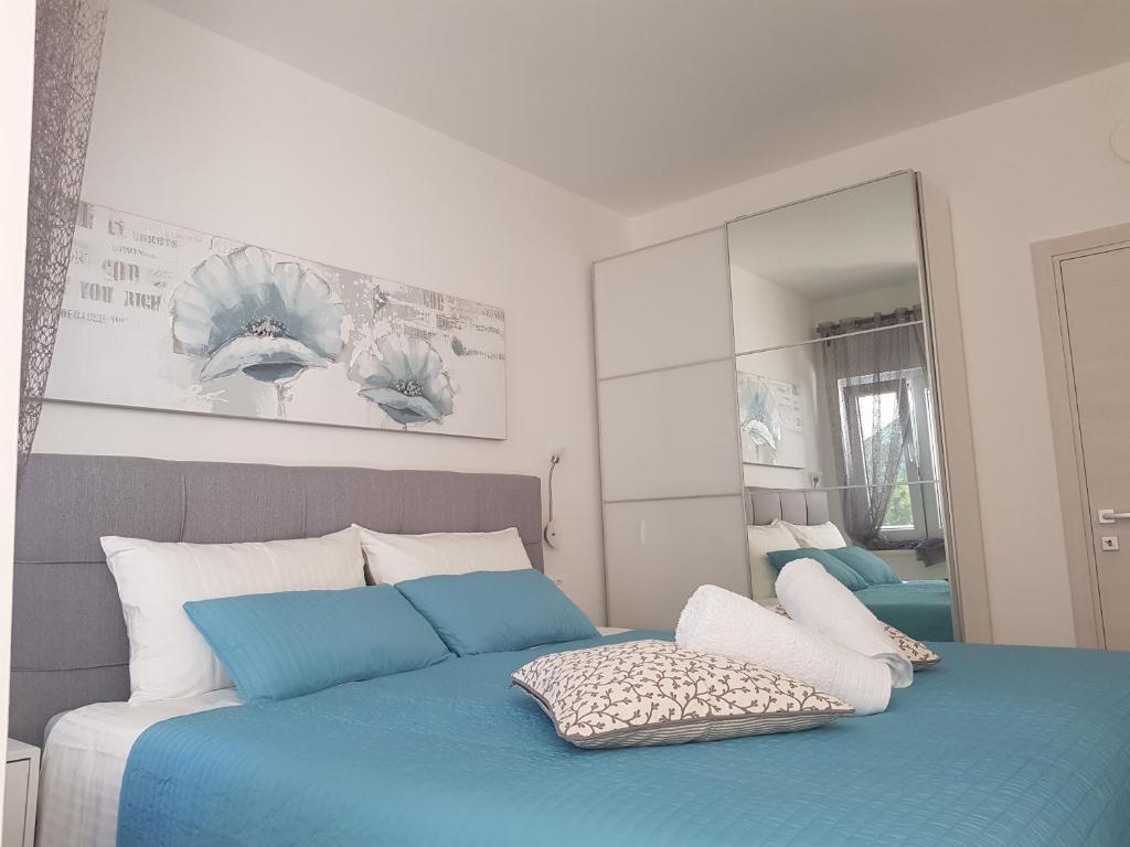 a bedroom with a blue bed and a mirror at eVita Fazana Premium Studio Apartments in Fažana
