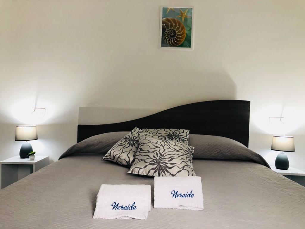 a bedroom with a bed with two white signs on it at Nereide in Tropea