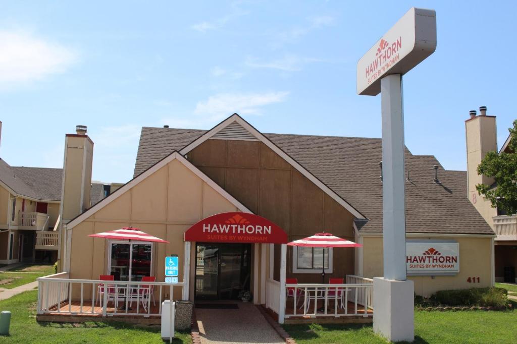 un restaurante con sombrillas rojas frente a un edificio en Hawthorn Suites Wichita East, en Wichita