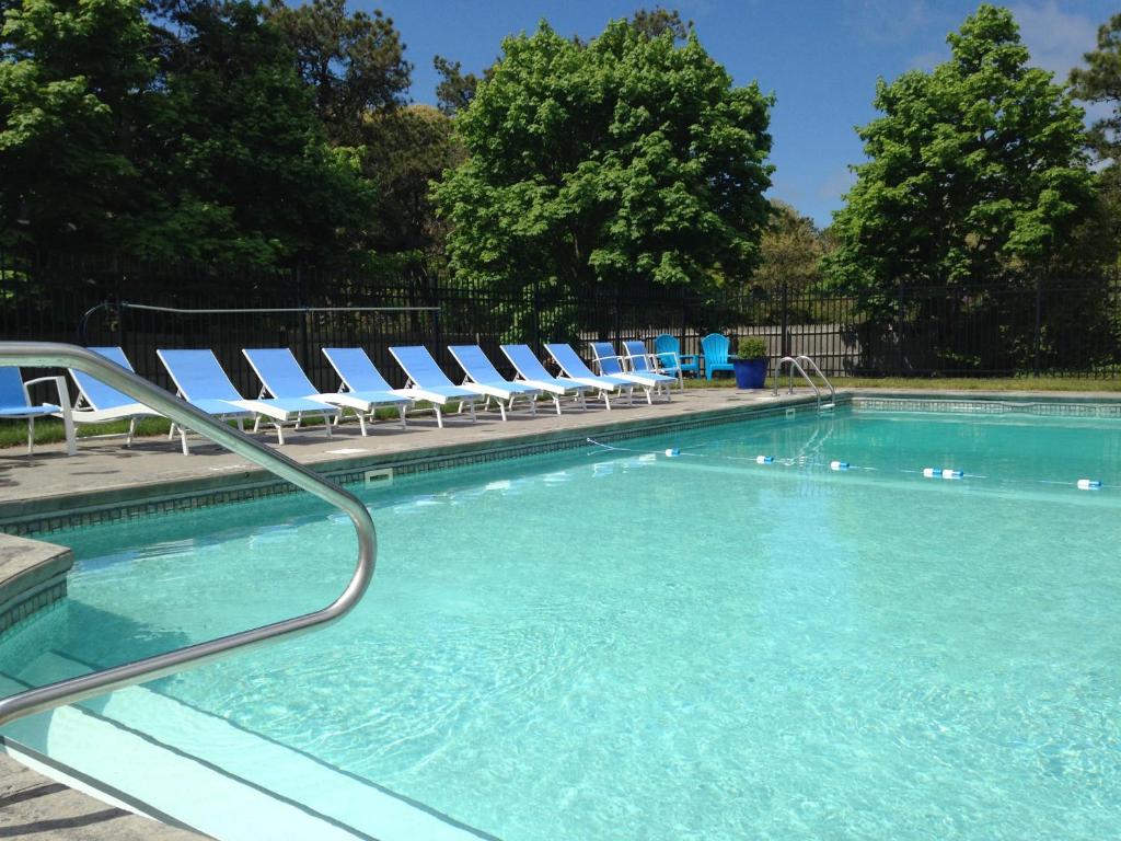 uma piscina com espreguiçadeiras e cadeiras em Chatham Seafarer Inn em Chatham