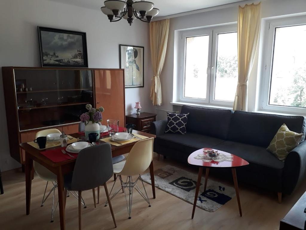 a living room with a blue couch and a table at Modern retro apartament Katowice in Katowice
