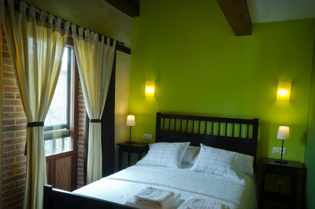 a green bedroom with a bed and a window at Apartamentos Playa Galizano in Galizano