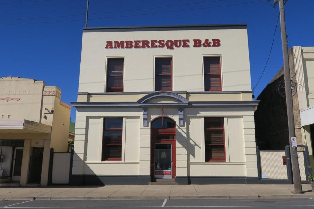een groot wit gebouw met een bord erop bij Amberesque B&B in Rutherglen