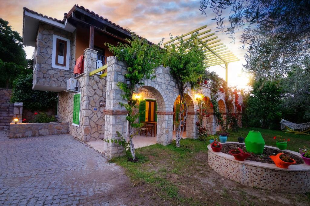 ein Steinhaus mit einer Terrasse und einem Garten in der Unterkunft Olive Farm Of Datca Guesthouse in Datca