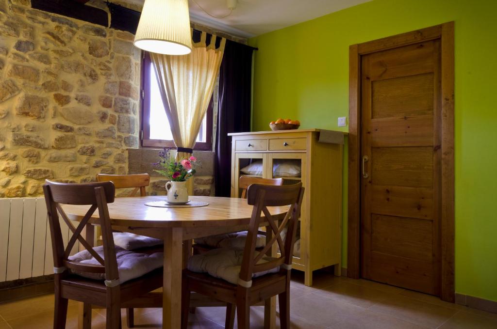 a dining room with a wooden table and chairs at Apartamentos Playa Galizano in Galizano