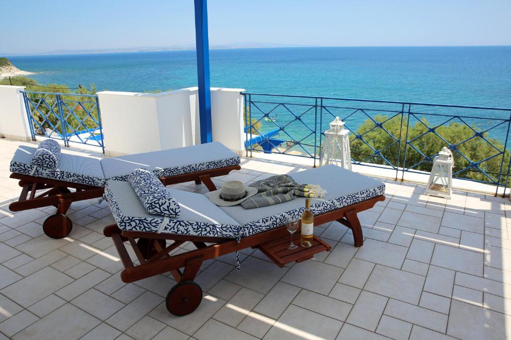 un patio con una mesa y una silla y el océano en Aliki Studios en Paralia Agias Foteinis