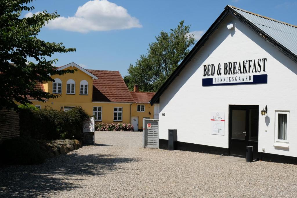 a white building with a sign that reads bad a breakfast limited at Benniksgaard Bed & Breakfast in Gråsten