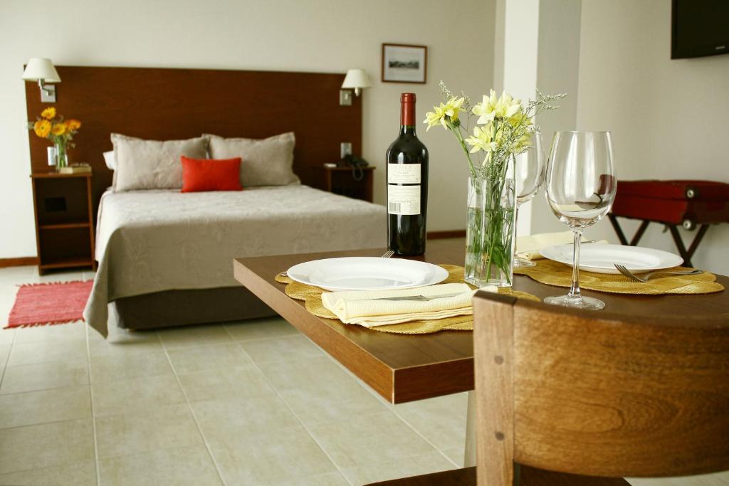 a bedroom with a bed and a table with a bottle of wine at DonSuites in Corrientes