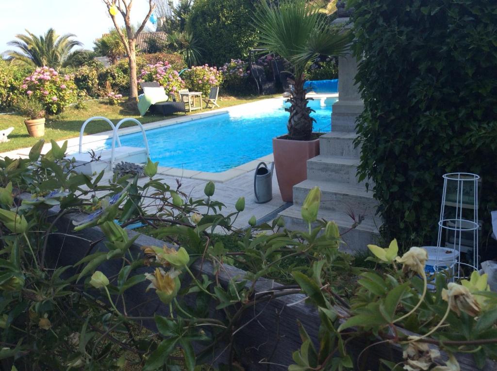 uma piscina num quintal com flores e plantas em Roulotte de luxe vue mer 180° ,et un ha de verdure em Plougastel-Daoulas