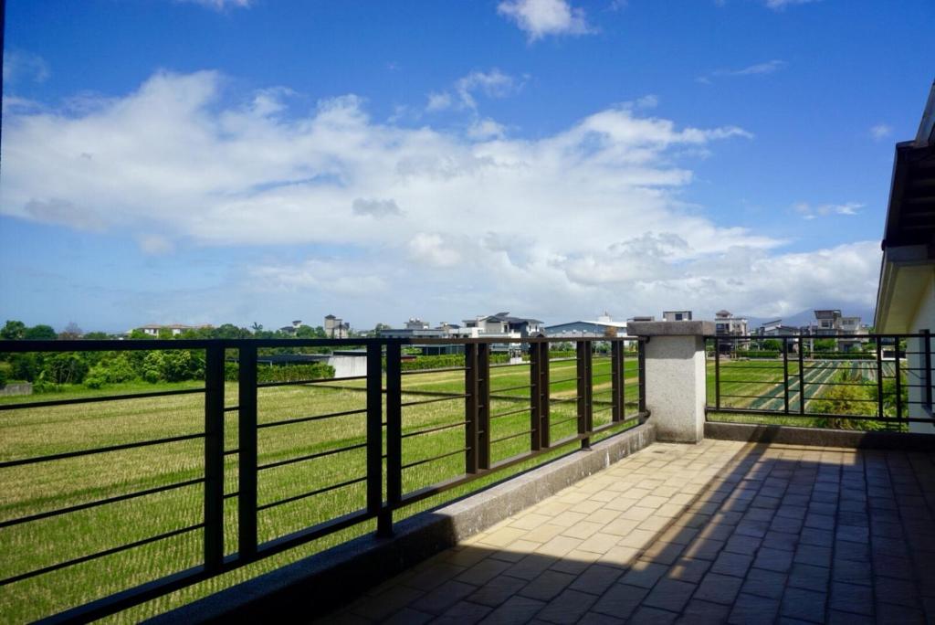 a balcony with a view of a field at CarNo B&amp;B in Yuanshan