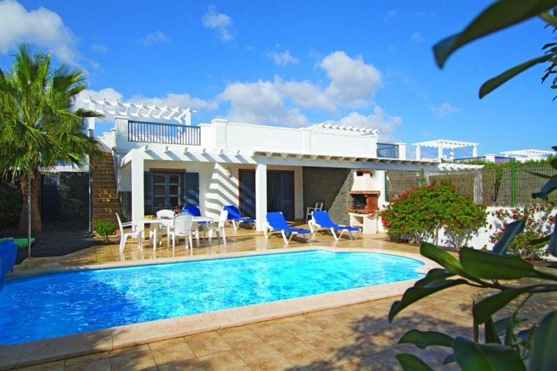 uma villa com piscina em frente a uma casa em Sun Grove Villas & Spa em Playa Blanca