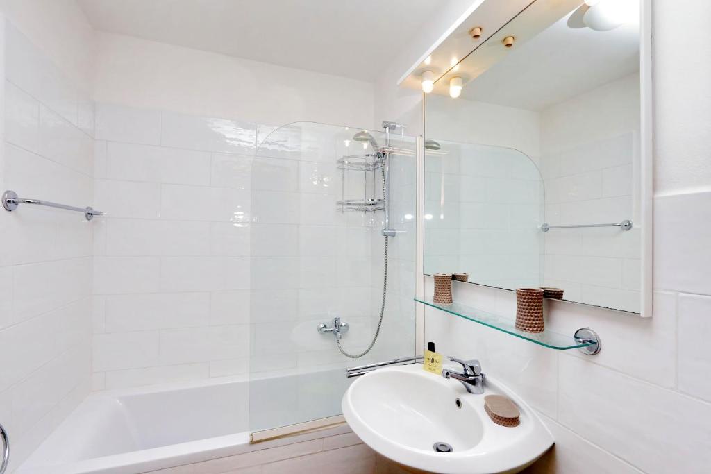 a white bathroom with a sink and a shower at Agriturismo Pimpinnacolo in Porto Ercole