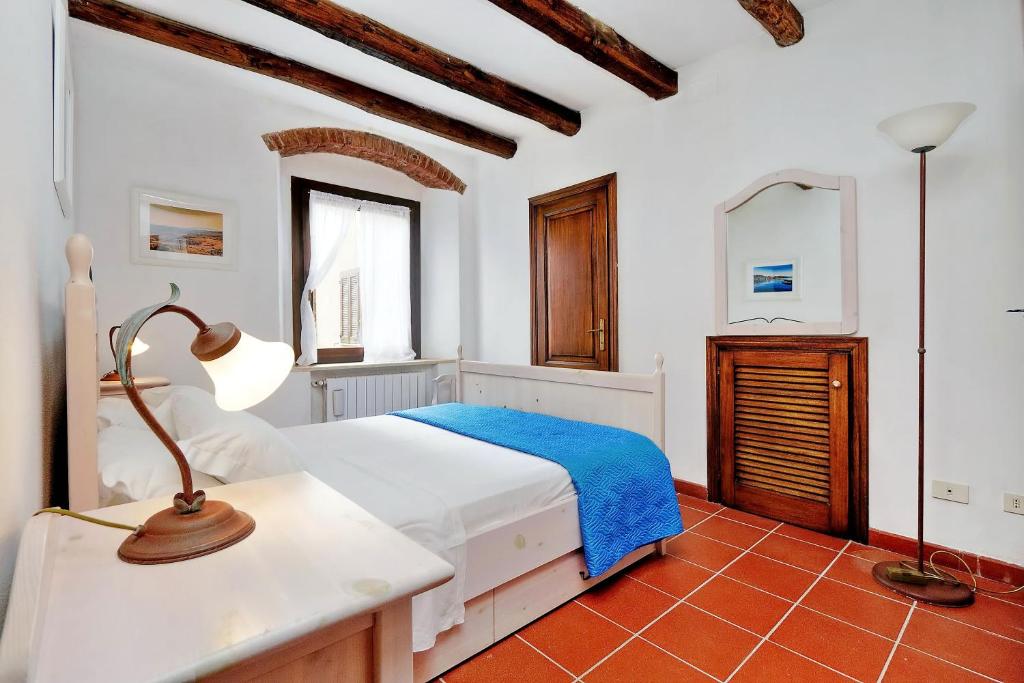 a bedroom with a bed and a lamp and a mirror at Agriturismo Pimpinnacolo in Porto Ercole