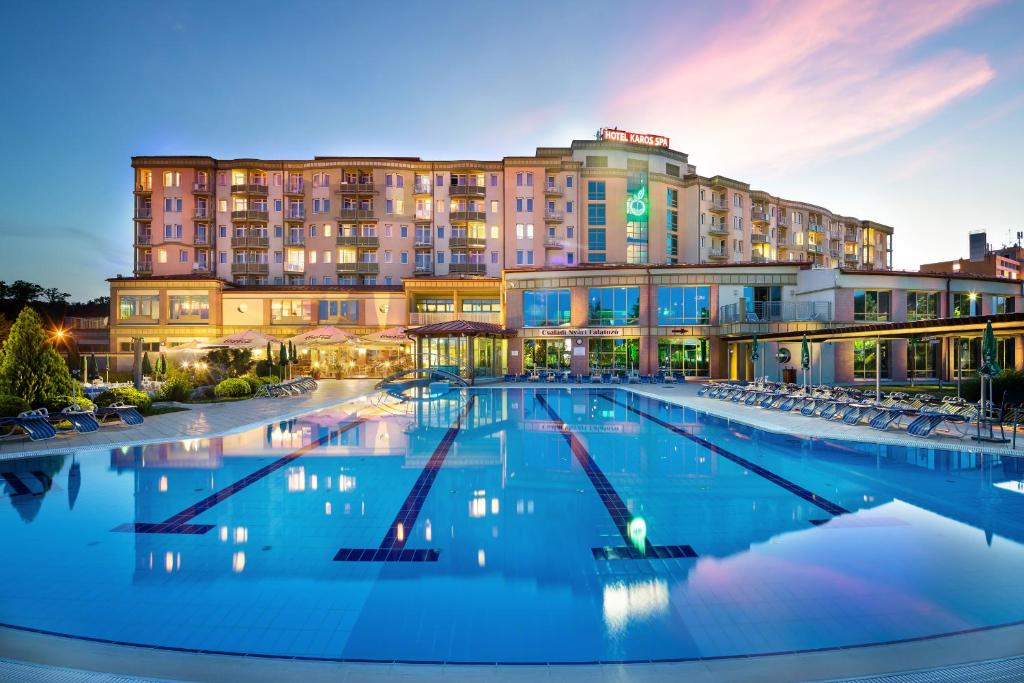 a large swimming pool in front of a hotel at Hotel Karos Spa in Zalakaros