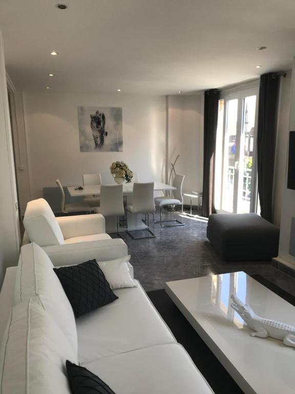 un soggiorno con divano bianco e tavolo di LE COEUR DE DEAUVILLE - 2 PIECES DESIGN EN HYPERCENTRE DE DEAUVILLE a Deauville