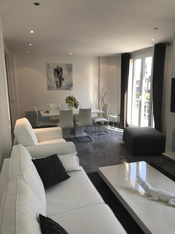 a living room with a white couch and a table at LE COEUR DE DEAUVILLE - 2 PIECES DESIGN EN HYPERCENTRE DE DEAUVILLE in Deauville