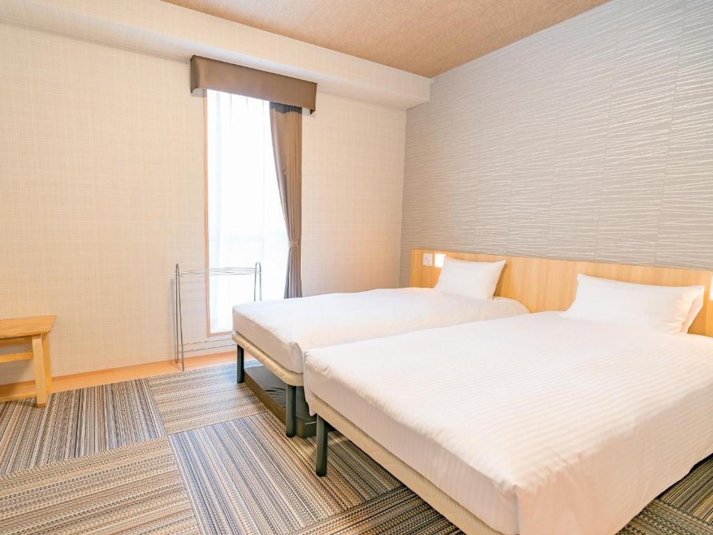 Postel nebo postele na pokoji v ubytování TABINO HOTEL Sado