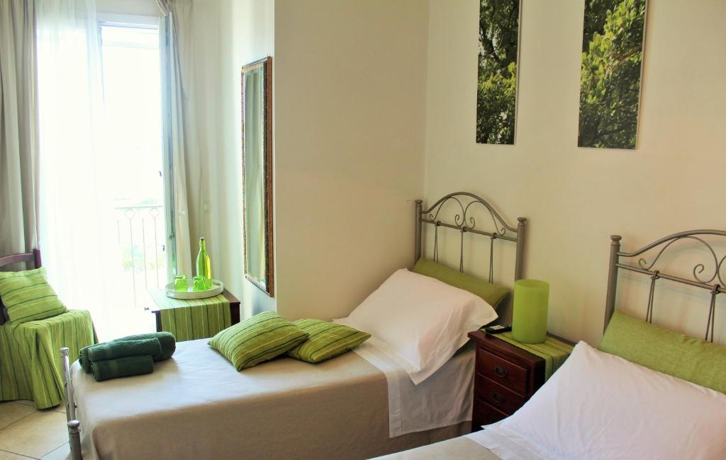 1 dormitorio con 2 camas individuales y ventana en B&B La Porta D'Oriente, en Martano