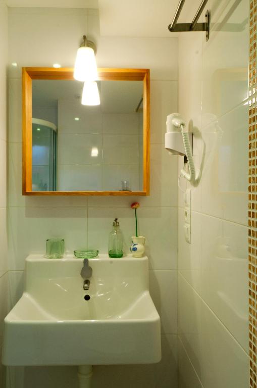 a bathroom with a sink and a mirror and a shower at Apartamentos Playa Galizano in Galizano