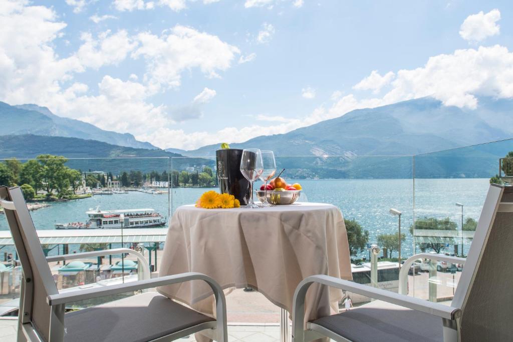 un tavolo su un balcone con vista sull'acqua di Exclusive Suites Riva a Riva del Garda