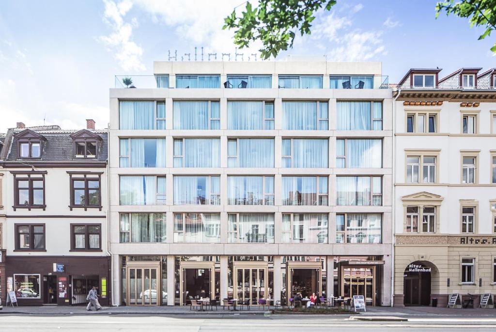 un edificio de oficinas con grandes ventanas en una calle de la ciudad en Bergheim 41 Hotel im Alten Hallenbad en Heidelberg