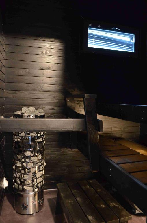 a log cabin with a window and a trash can at Rauhalahti Holiday Homes in Kuopio