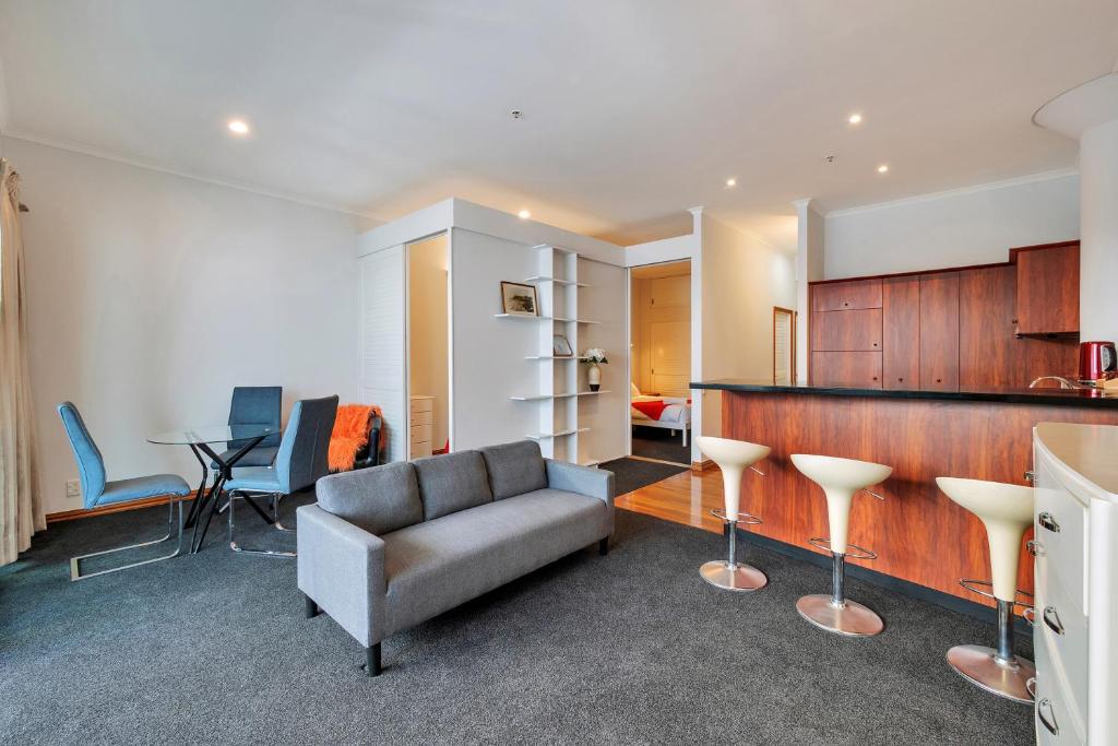 un soggiorno con divano, tavolo e sedie di Viaduct Loft 2BR Delight with Netflix and Aircon ad Auckland