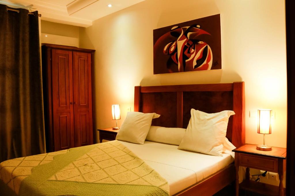 a bedroom with a bed and a painting on the wall at Tchero Appartement 2 in Douala