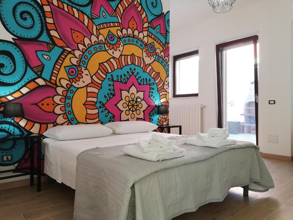 NevianoにあるCasa Ninìのベッドルーム1室(壁に絵画が描かれたベッド1台付)